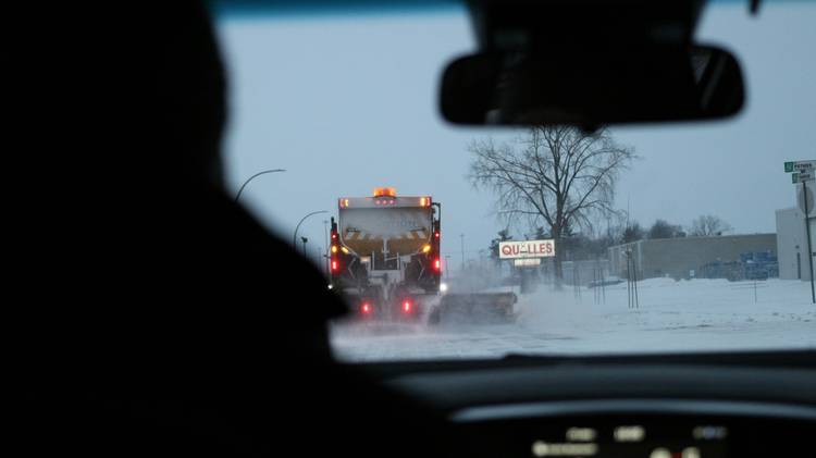 Driver examining bumper damage after city collision in Winnipeg