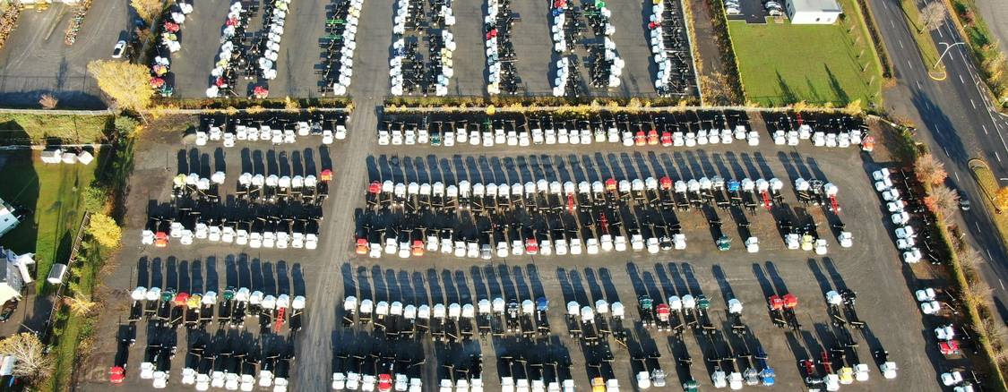 Rows of used cars at a Winnipeg dealership contrasting with a driveway private sale