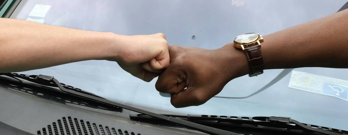 Buyer and seller shaking hands while exchanging car keys after successful negotiation in a snowy Winnipeg dealership lot