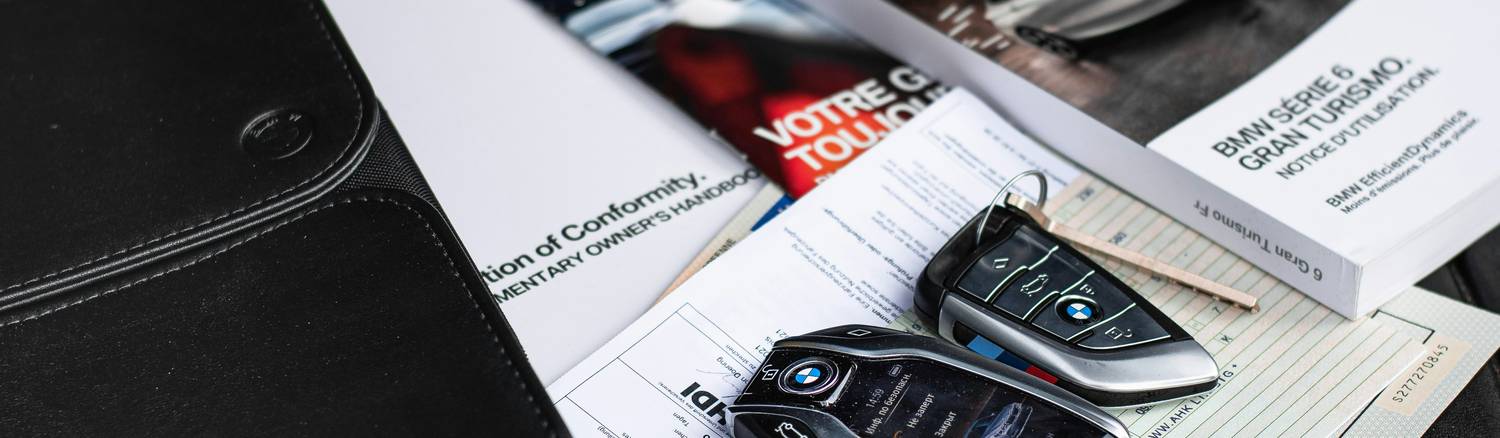 Stock photo of hands holding car insurance renewal documents and car keys, representing renewal process in Manitoba 