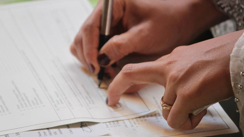 Commercial driver signing insurance documents at an MPI broker office