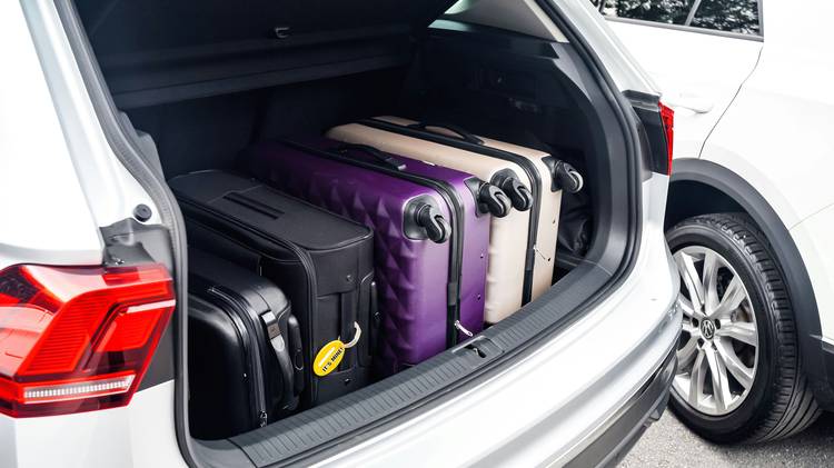 Family loading luggage into rental car for US road trip